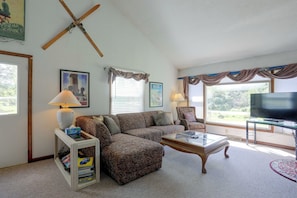 A living room with a sofa, armchairs, a coffee table, a television, and a window with curtains. - Carley House Too: Pet Friendly, Hot Tub, Fire Pit! (Ellicottville)