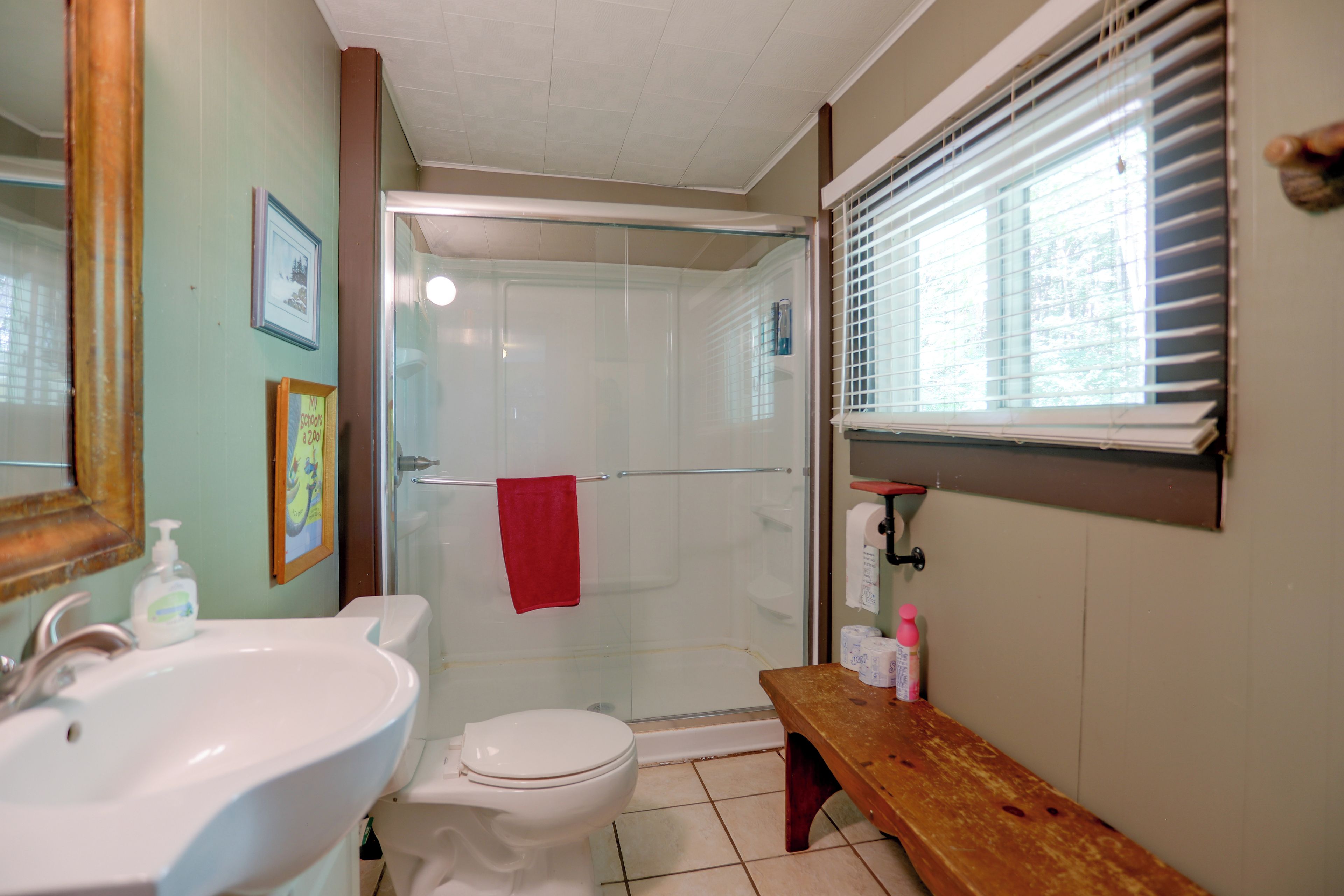 A bathroom with a sink, toilet, and shower area.