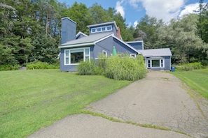 A two-story house with a paved driveway leading to the entrance.