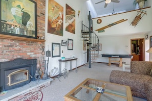 A living room with a fireplace, a billiards table, and a spiral staircase. - Carley House Too: Pet Friendly, Hot Tub, Fire Pit! (Ellicottville)