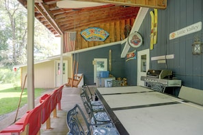 A covered outdoor area with a long table, chairs, and a grill. - Carley House Too: Pet Friendly, Hot Tub, Fire Pit! (Ellicottville)