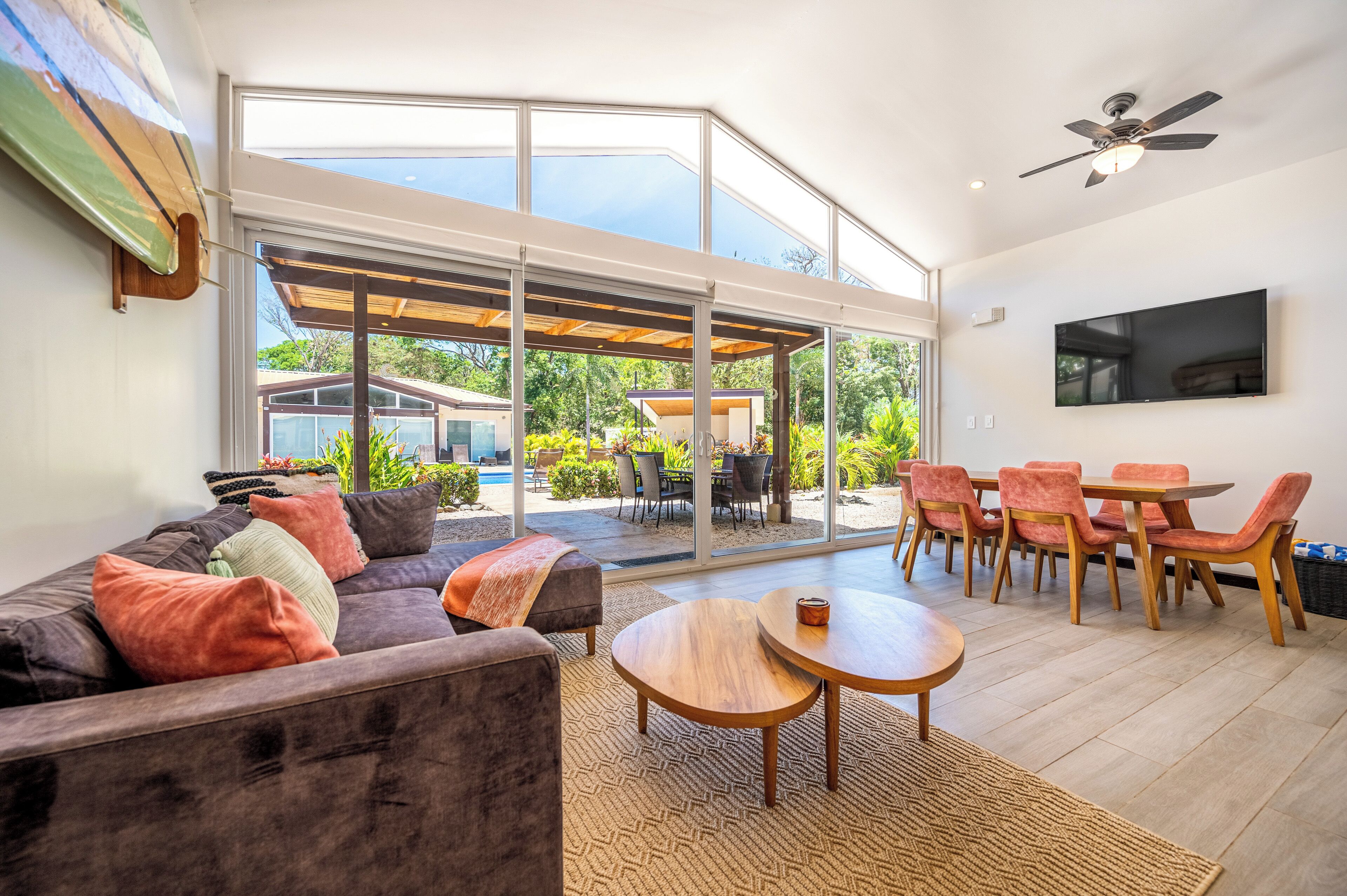 Uma sala de estar moderna com sofá, mesa de centro e área de jantar com cadeiras.