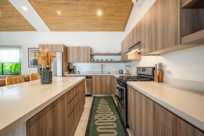 Una cocina moderna con armarios de madera, electrodomésticos de acero inoxidable y una isla central.