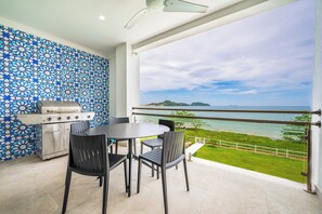 A balcony with a view of the sea, a grill, and a table with chairs. - Oceanfront Escape in Playa Potrero, Costa Rica (Tempate)