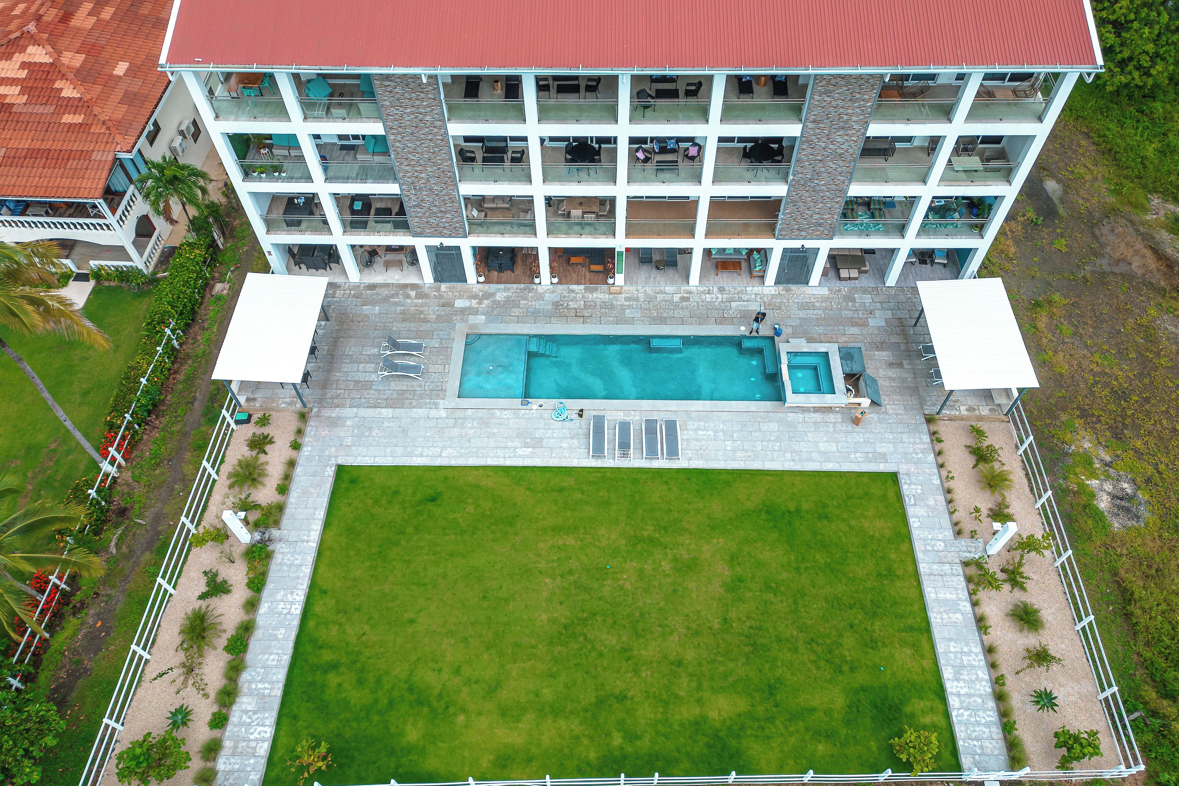Un hôtel à plusieurs étages doté d’une piscine, d’un espace extérieur aménagé et d’une pelouse bien entretenue.