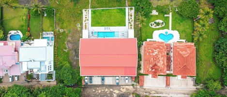 Vista aérea de una zona residencial con varios edificios, una piscina y un elemento acuático con forma de corazón.