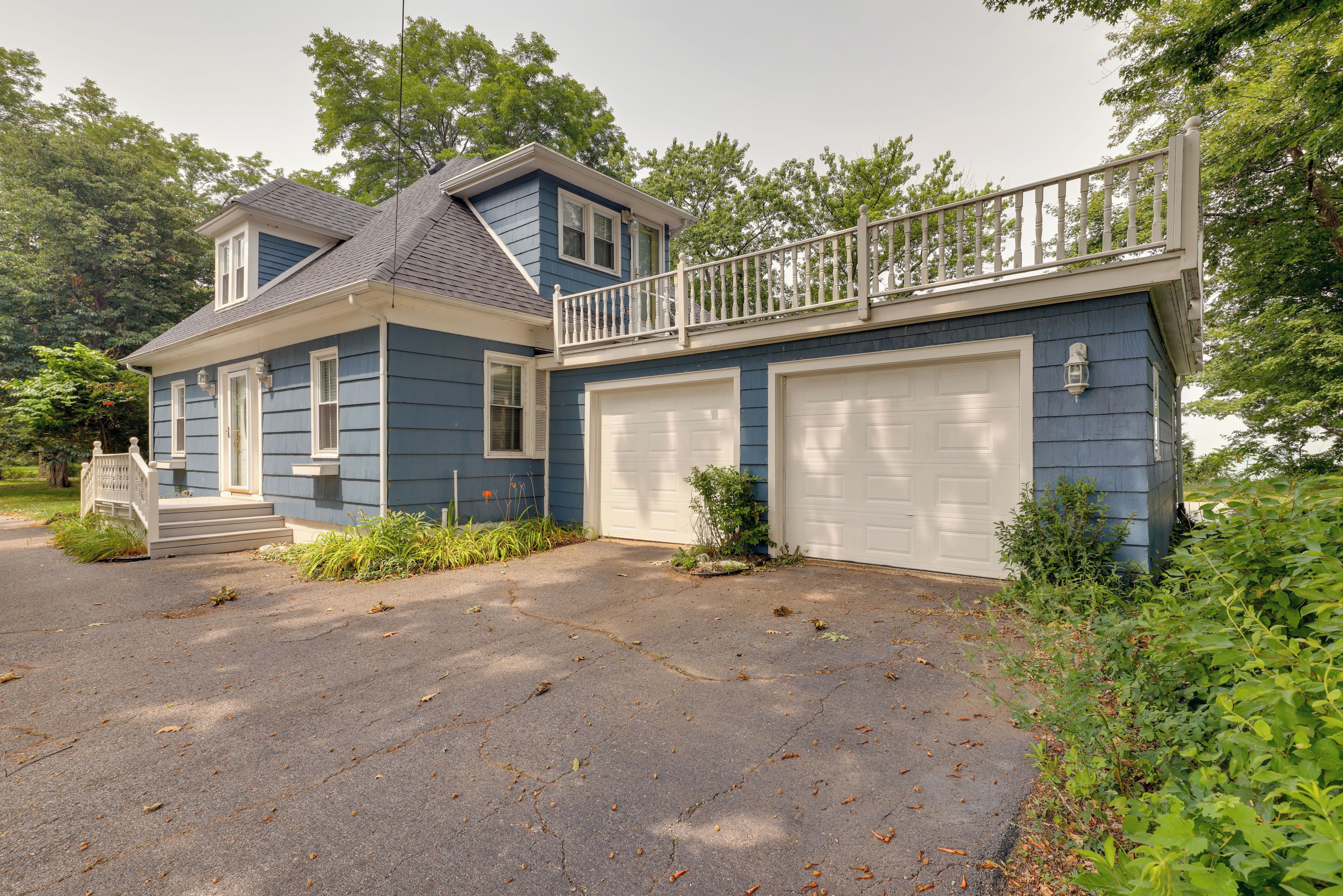 A two-story house with a front porch, a garage, and a balcony.