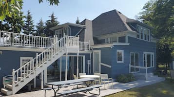 A two-story house with a covered patio, a staircase, and a dining area.