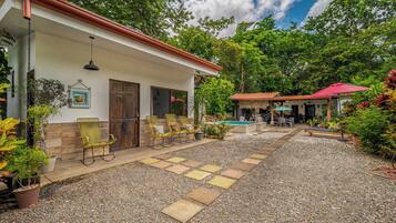 A house with a pool, outdoor seating, and a garden.