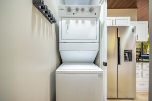 A compact kitchen with a built-in washer and dryer, a refrigerator, and a sink.