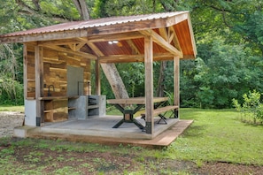 A rustic wooden structure with a metal roof, a built-in sink, and a picnic table. - Shared Pool Access: Updated Apt in Playa Avellanas (Tamarindo)