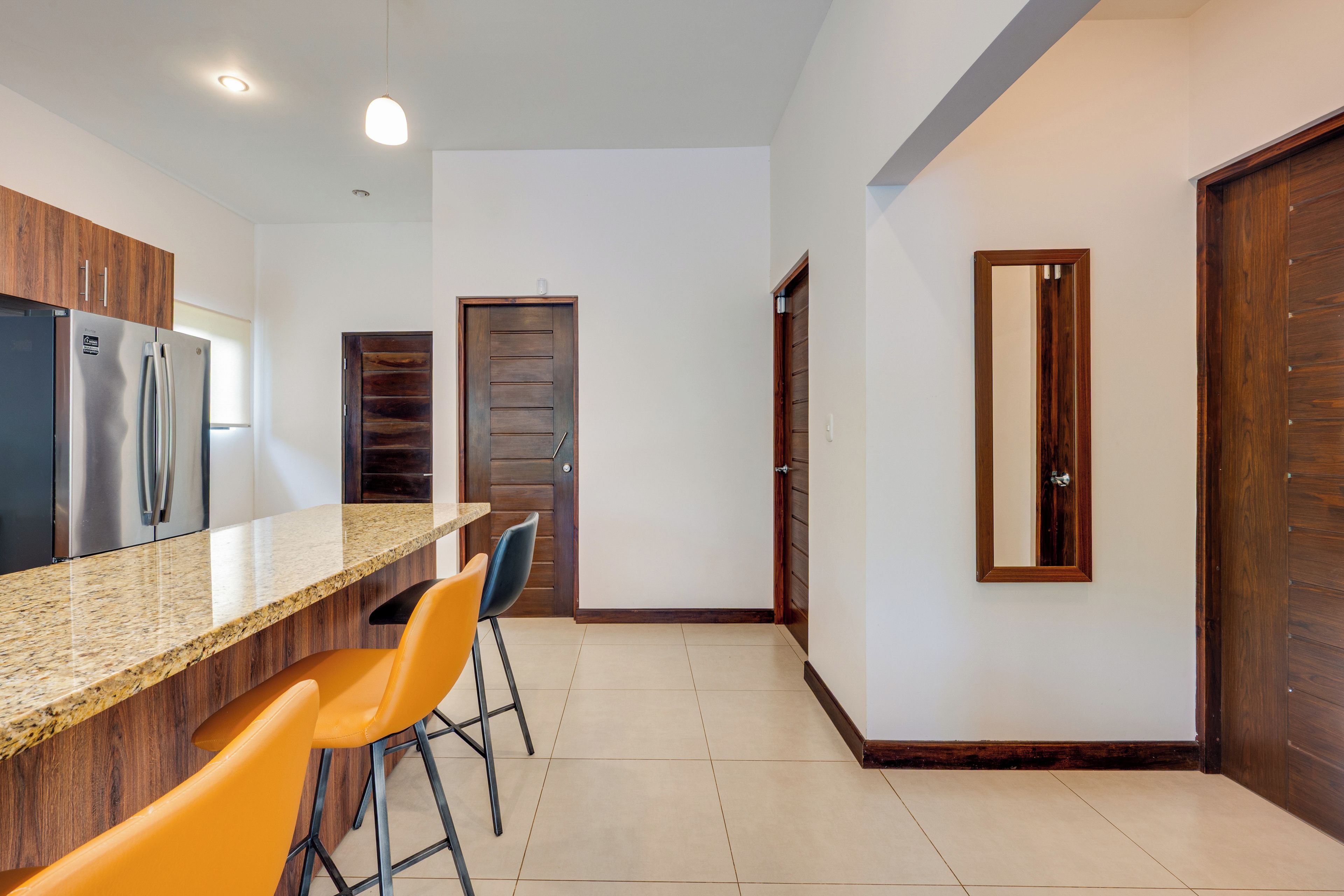 A modern kitchen with a granite countertop, stainless steel appliances, and wooden cabinets.