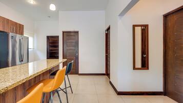 A modern kitchen with a granite countertop, stainless steel appliances, and wooden cabinets.