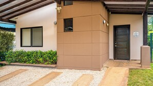 A building with a brown facade, a dark door, and a window. - Modern + Spacious Tamarindo Home w/ Private Pool (Tamarindo)