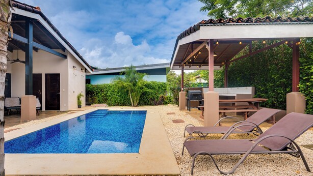 A swimming pool with lounge chairs and a covered patio area. - Modern + Spacious Tamarindo Home w/ Private Pool (Tamarindo)