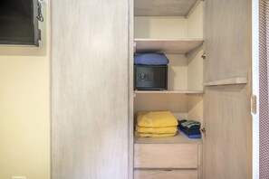 A wardrobe with multiple shelves and drawers, containing folded towels and a small electronic device. - Resort-style Pool: Playa Ocotal Condo Near Beach! (Sardinal)