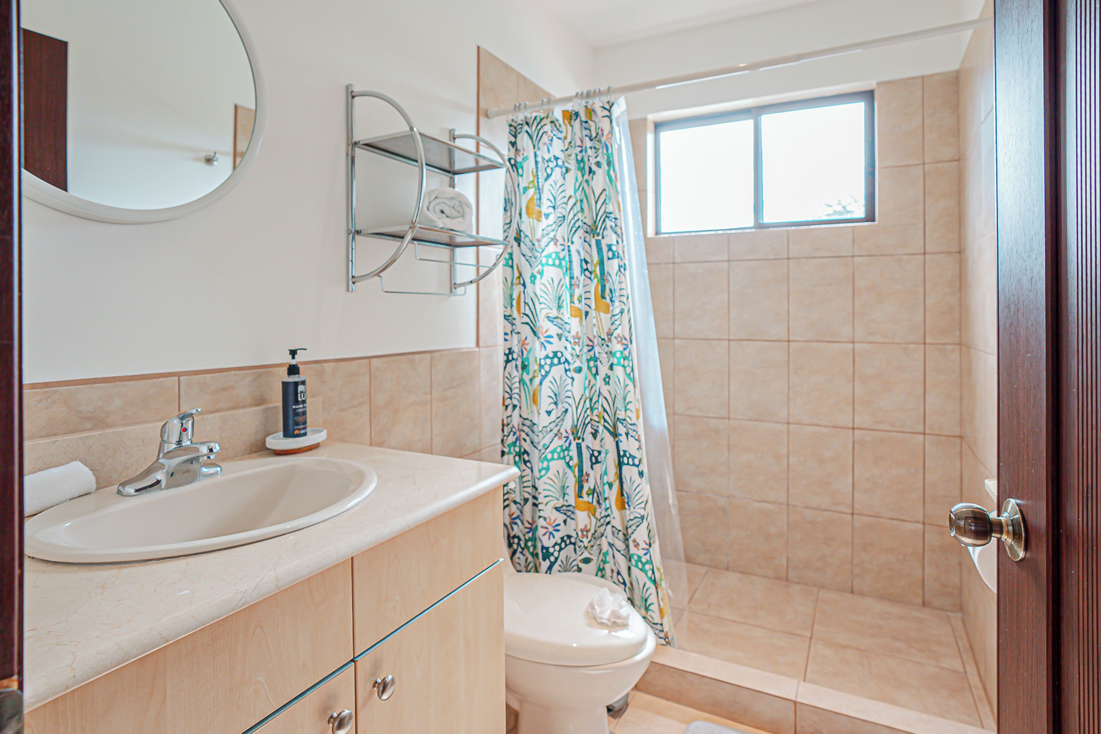 A bathroom with a sink, toilet, and shower area.