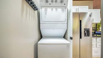 A compact kitchen with a built-in washer and dryer, a refrigerator, and a microwave.