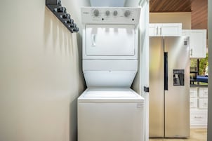 Cocina compacta con lavadora y secadora integradas, refrigerador y microondas.