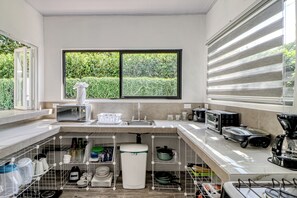 A modern kitchen with a large window, stainless steel appliances, and organized storage.