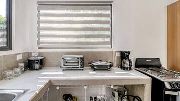 A modern kitchen with a built-in oven, a coffee maker, and a toaster.