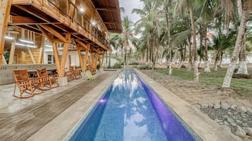 A poolside area with wooden deck seating and a pool.