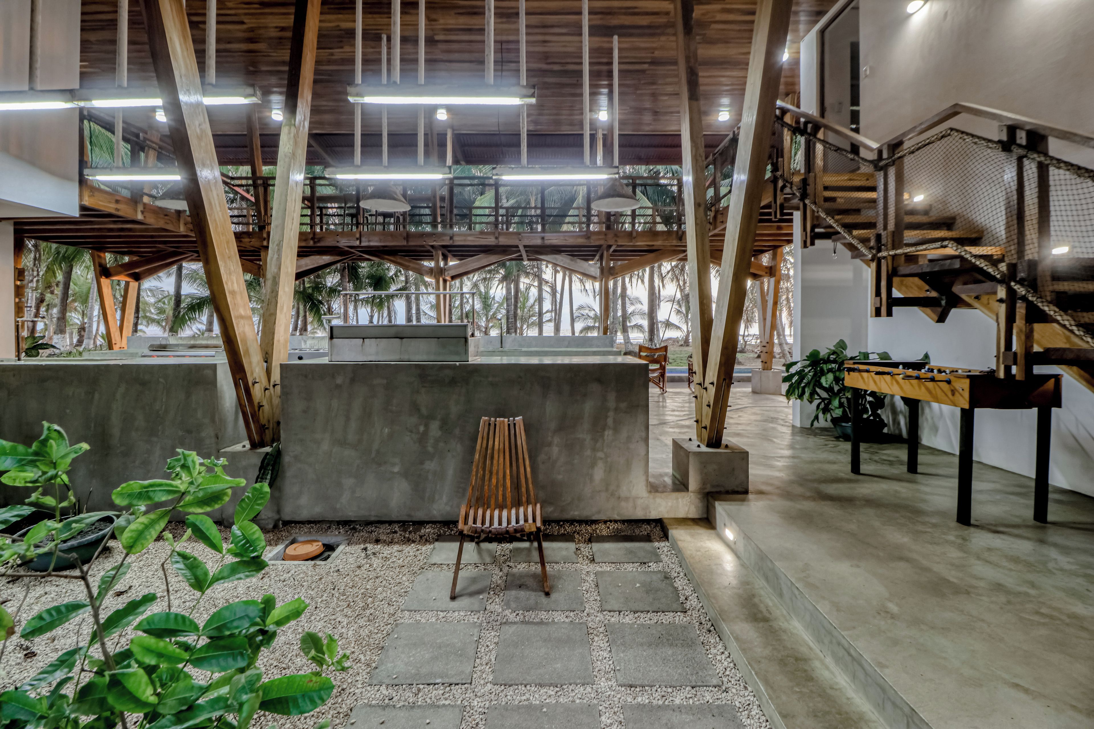 A spacious indoor area with a concrete bench, a wooden chair, and a foosball table.