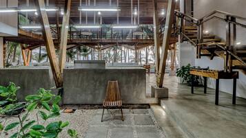 A spacious indoor area with a concrete bench, a wooden chair, and a foosball table.