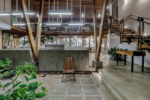A spacious indoor area with a concrete bench, a wooden chair, and a foosball table.