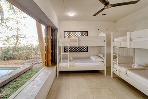 A room with bunk beds, a ceiling fan, and a view of the outdoors. - Award-winning Oceanfront Home w/ Pool & Hot Tub! (Bejuco)