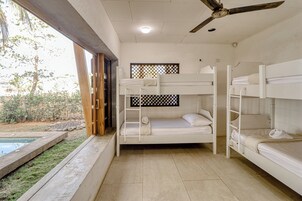 A room with bunk beds, a ceiling fan, and a view of the outdoors.