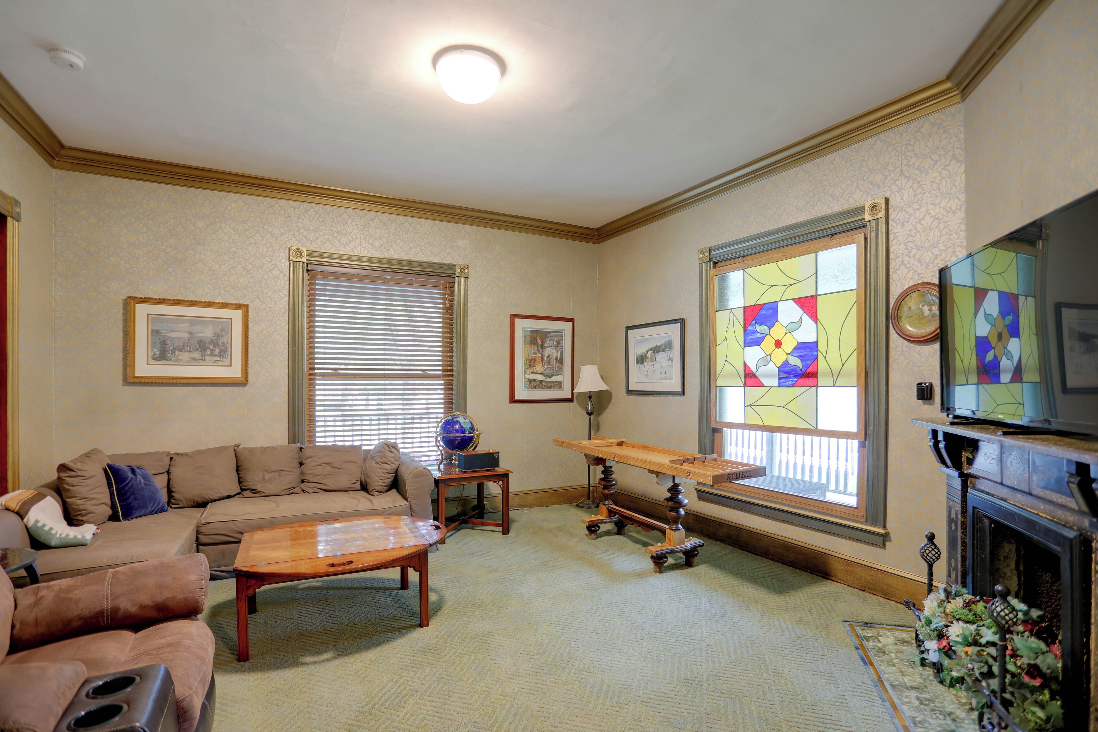 A living room with a sofa, coffee table, globe, and fireplace.