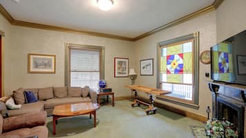 A living room with a sofa, coffee table, globe, and fireplace.