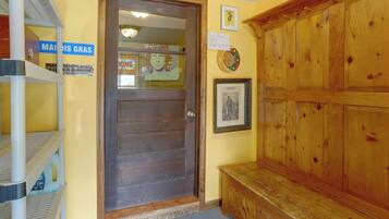A wooden door with a sign requesting guests to remove boots in the mudroom.