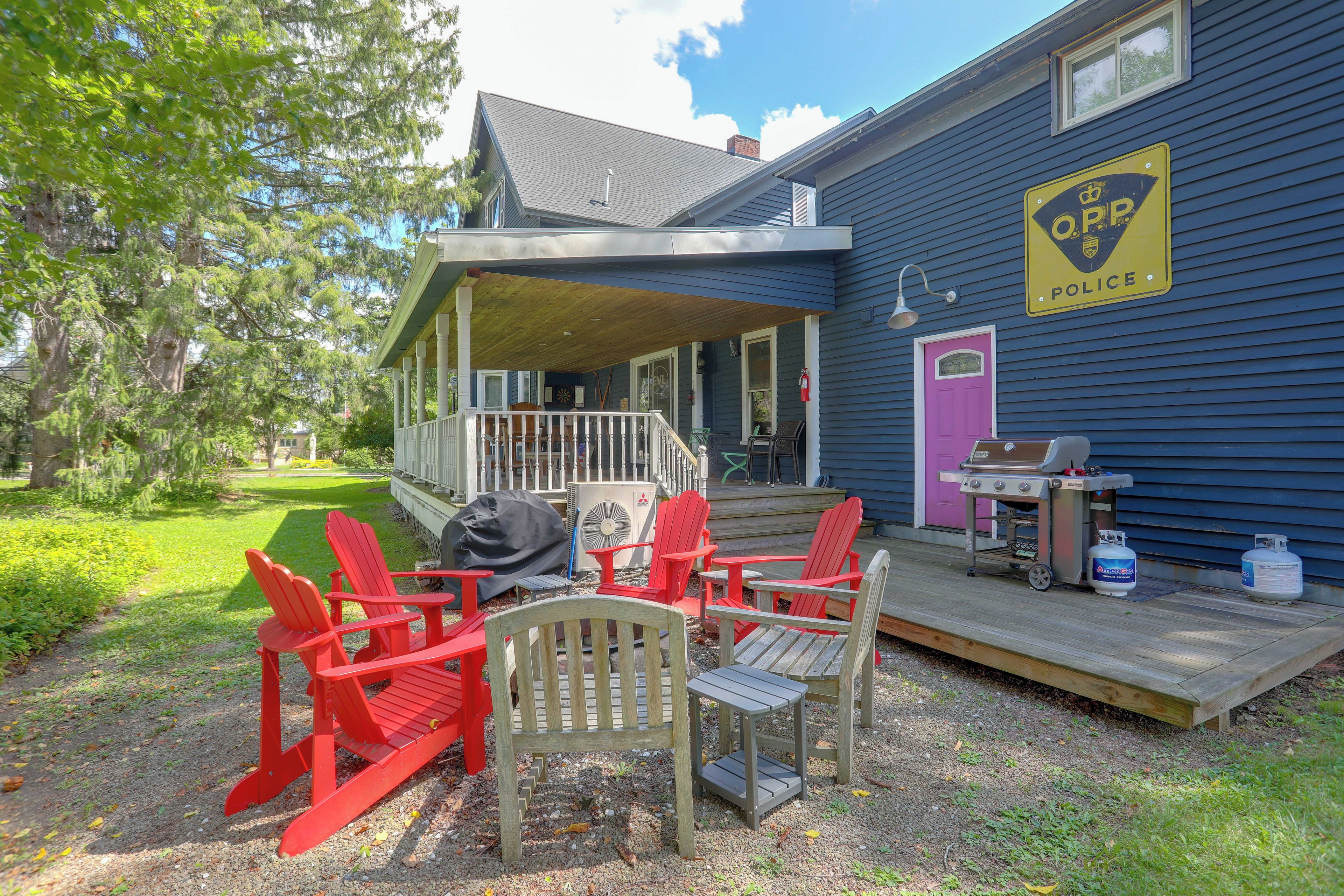 A house with a porch, outdoor seating, and propane tanks.