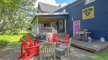 A house with a porch, outdoor seating, and propane tanks.
