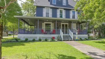 A two-story house with a covered porch and a front entrance.