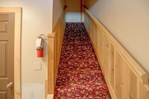 A narrow staircase with a wooden handrail and carpeted steps. - Downtown Spacious 5BR w/ Game Room (Ellicottville)