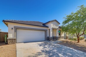A residential building with a garage, stone foundation, and a landscaped front yard. - Yard, Patio & Spacious Interior! Casa Grande Home (Casa Grande)