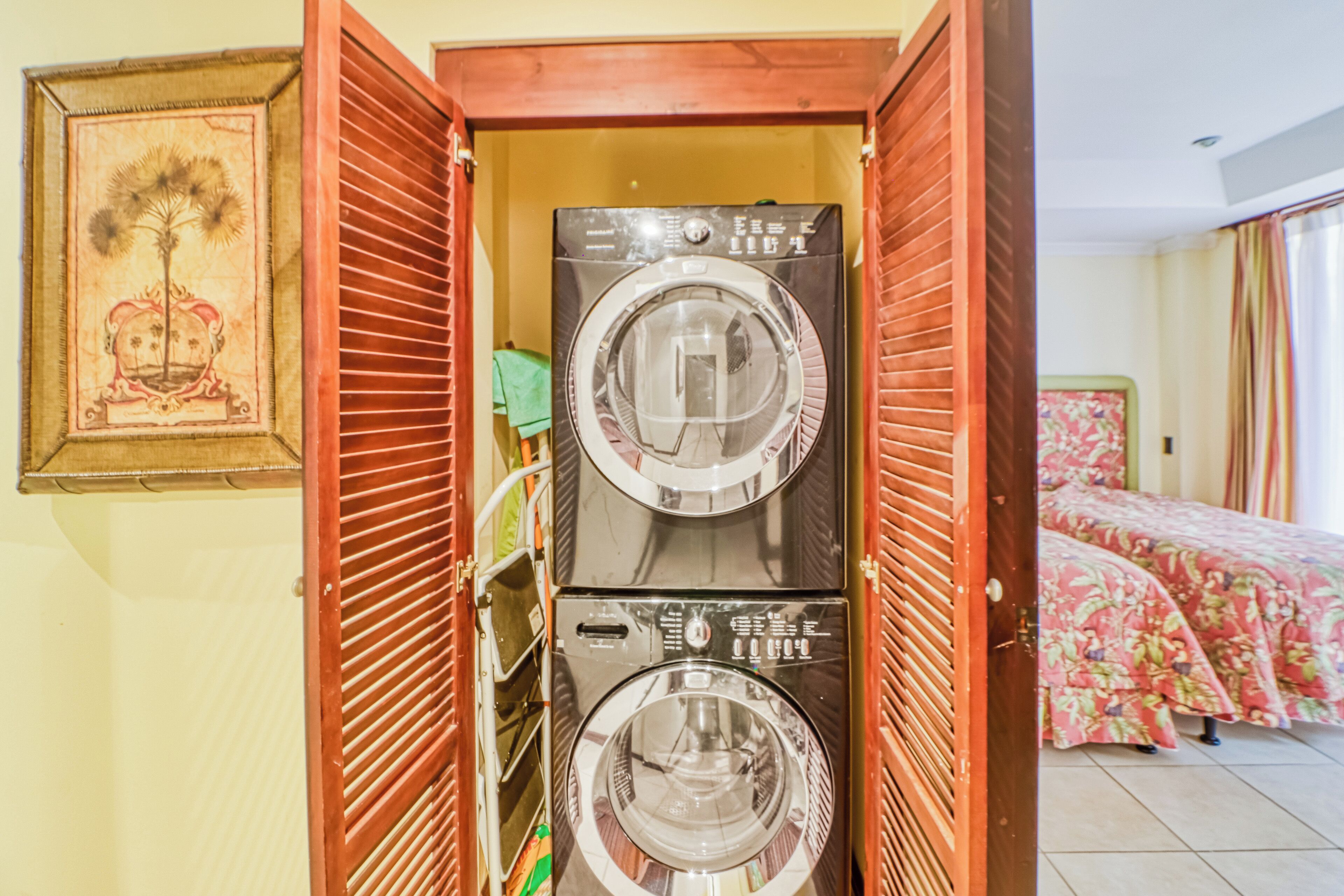 A laundry room with two washing machines and a drying rack.