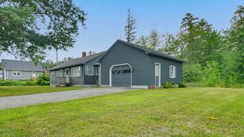 A single-story house with a front garage, a covered porch, and a well-maintained lawn.