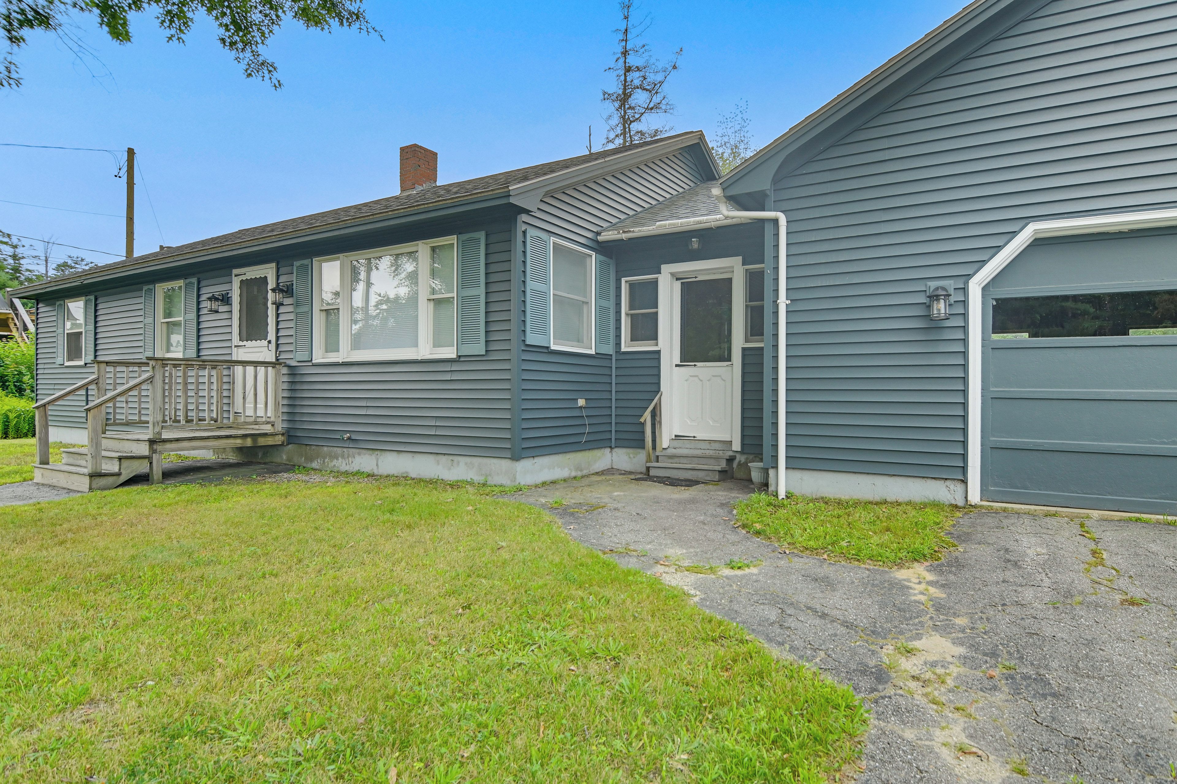 A two-story house with a front porch, a garage, and a small front yard.