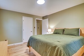 A bedroom with a bed, a nightstand, a lamp, and two doors. - 5 Mi to Sunday River Resort! Mtn-view Home (Bethel)