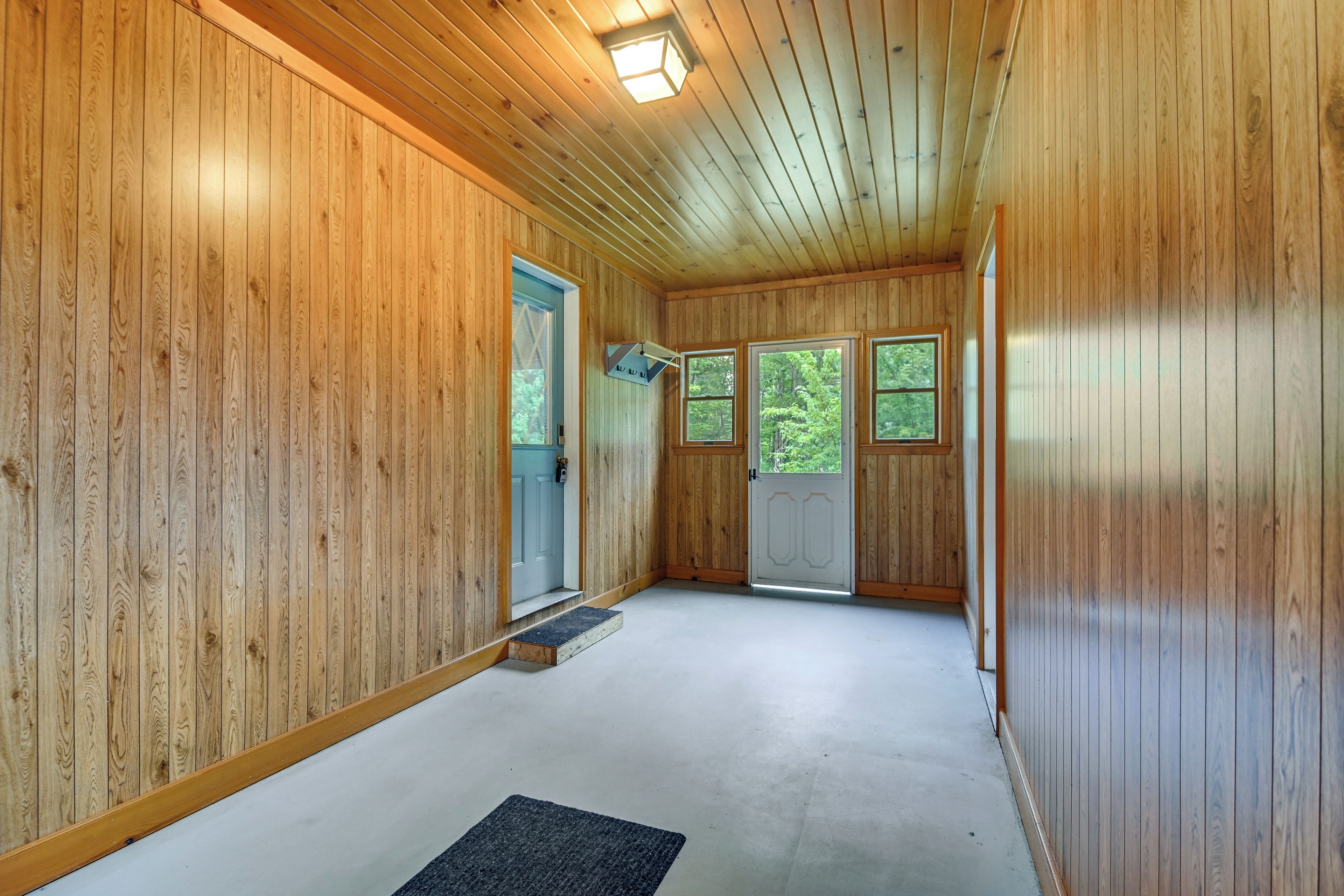 Un intérieur en bois avec une porte, une fenêtre et un sonnette.