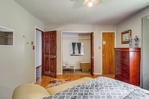 Un dormitorio con cama, cómoda y ventilador de techo.