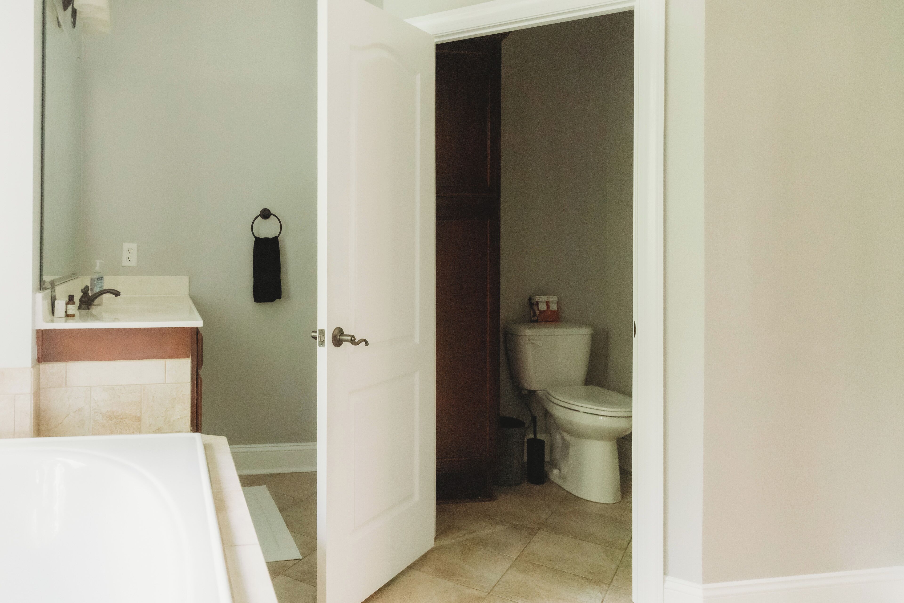 A bathroom with a white sink, a mirror, a towel rack, and a toilet.