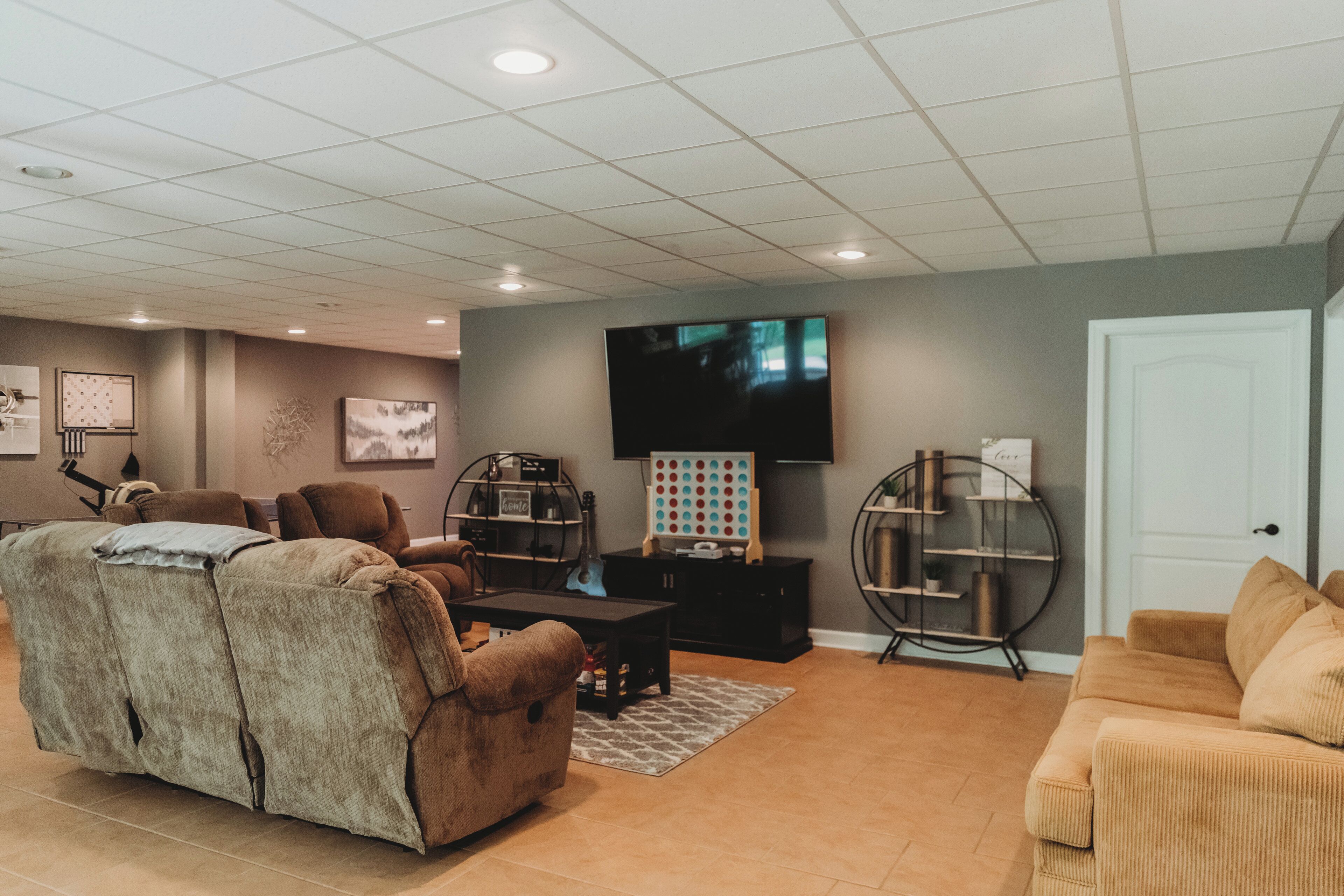 A living room with a sectional sofa, a TV mounted on the wall, and a coffee table.