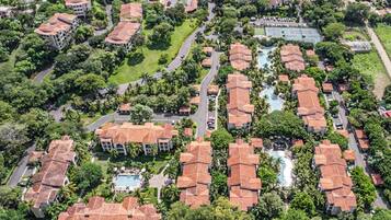 Vista aérea de una zona residencial con varios edificios, carreteras y zonas verdes.
