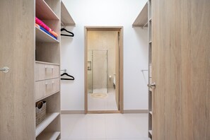 Passadís estret amb prestatgeries de fusta a ambdós costats, que condueix a una porta amb un panell de vidre.