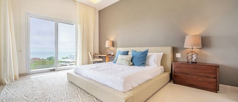 Quarto moderno com uma cama grande, duas luminárias de cabeceira, mesa de cabeceira de madeira e vista para o exterior por uma porta deslizante.